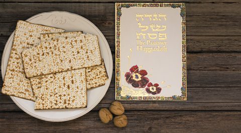 A plate containing some Matzah bread and a Haggadah (traditional Passover book).