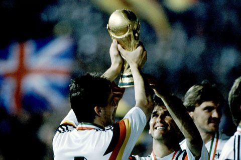 A West Germany football player holds up the World Cup and celebrates West Germany celebrating winning the World Cup in 1990. 