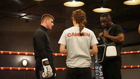 Idris Elba in a boxing ring with two members of Idris Elba's Fight School