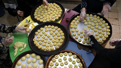 AFP Contributor/Getty Images Extended family members and neighbors gather together to make maamoul (Credit: AFP Contributor/Getty Images)