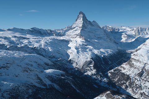 A sharply pointed mountain top that forms a pyramid shape.