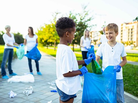 Two boys picking up litter in the community