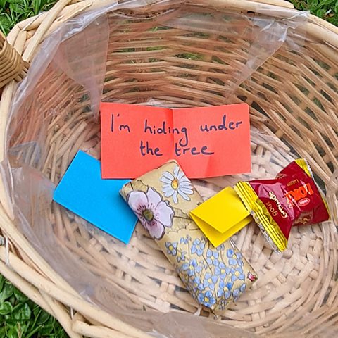 A basket with a treasure hunt glue and Eid gifts in it. The clue says "I'm hiding under the tree".