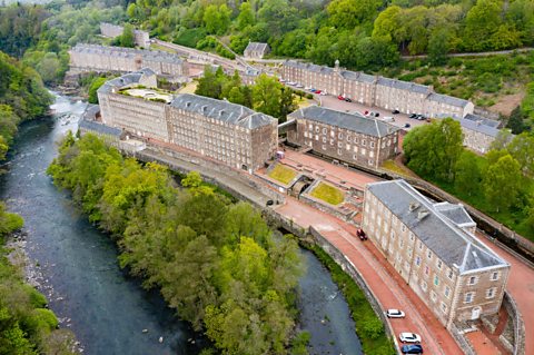 An aerial view of New Lanark. It was founded in 1786 by the industrialist, David Dale. As well as factories, New Lanark featured houses for the workers. 