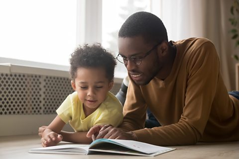 Parent and little boy read together.