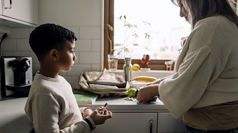 mother and son talking together in the kitchen 