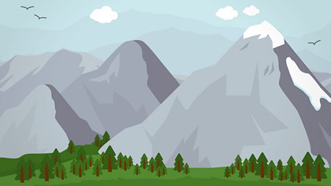 A range of mountains with a valley of trees at the base.