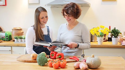 Lizzie and Katie stand in a kitchen