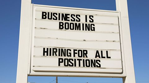 A sign that reads 'Business is booming. Hiring for all positions.'