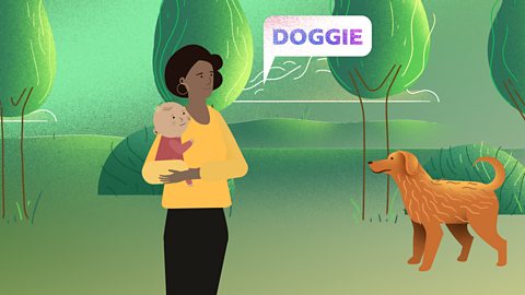 A mum and her baby are out in the park. They are looking at a dog. A speech bubble appears from the mum saying "doggie".