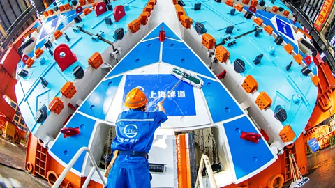 VCG/Getty A worker in Shanghai cleans a 3,200-tonne tunnel boring machine at a manufacturing base of Shanghai Tunnel Engineering Co (Credit: VCG/Getty)