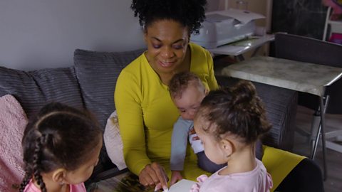 A grandma showing her 4 year old granddaughter a family photo album.