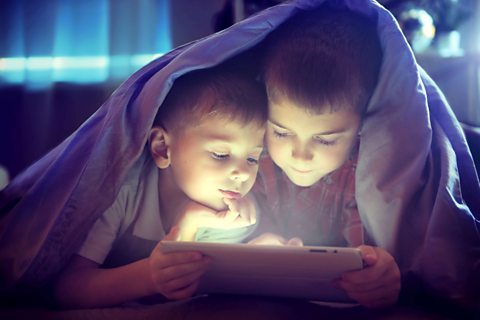 Two children explore a tablet together.