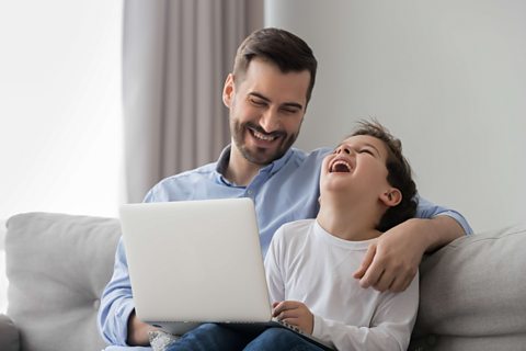 Parent and child look at laptop.