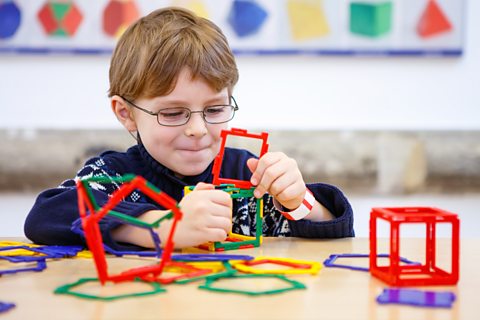 Child plays with colourful plastic blocks.