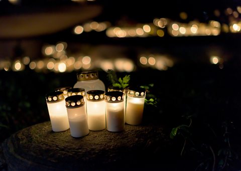 Candles and lanterns on gravestones at a Polish cemetery on All Saints' Eve.