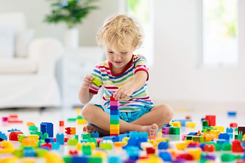 Little boy playing with colourful blocks.