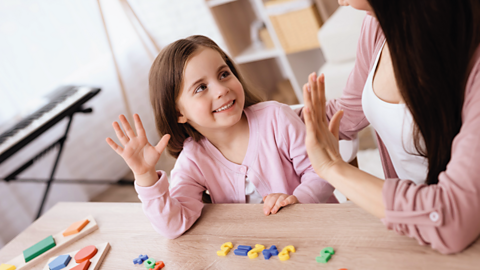 Little girl learns how to count with her parent.