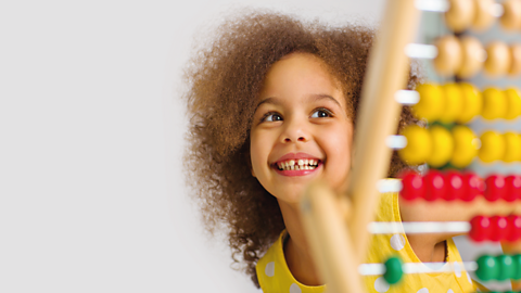 Girl laughing with an abacus.