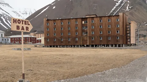 George Pachantouris/Getty Images The few remaining staff gather at the tiny bar of the Tulpan Hotel (Credit: George Pachantouris/Getty Images)