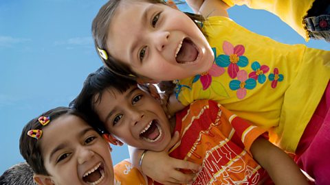 Three kids looks to camera screaming with joy