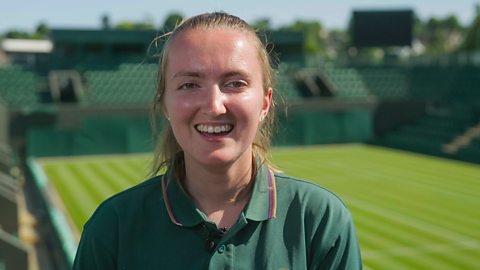 Rachel stood in front of a tennis court 