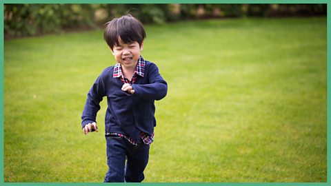 A young boy racing round a field