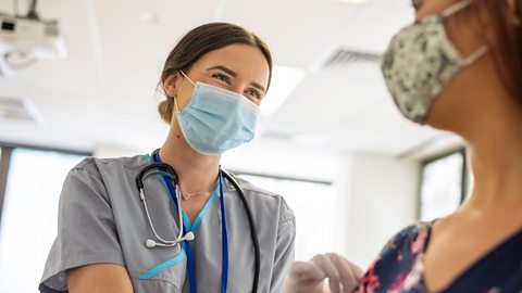 An image of a young nurse treating a patient