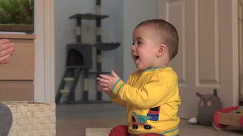 A baby boy clapping.