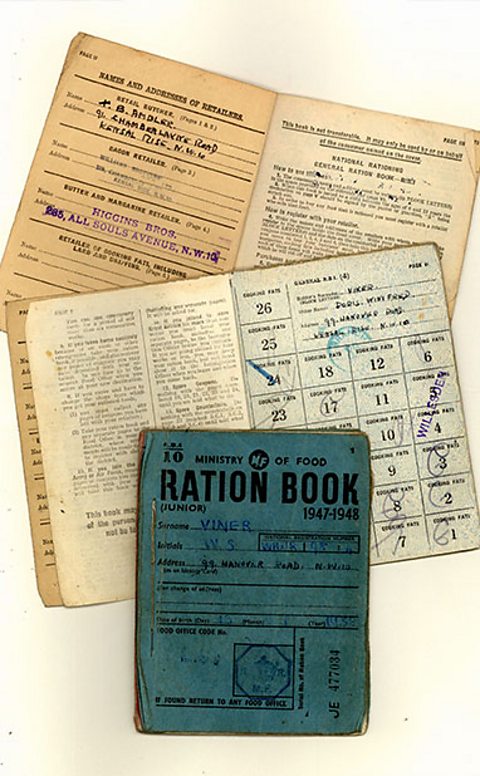 Picture of three British rationing books issued by the Ministry of food with the name and adresses of the retailers and holders
