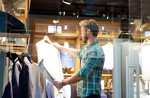 A man looking at a shirt. 