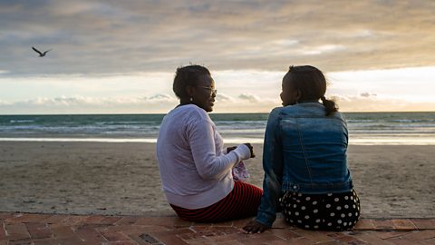 Mother and daughter talking by the sea