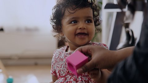 A little girl smiling at her mum.