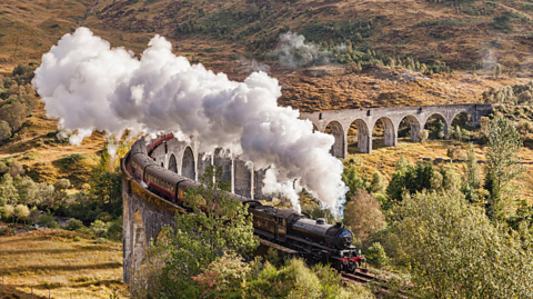 Glenfinnan viaduct and Jacobite steam train with billowing steam 