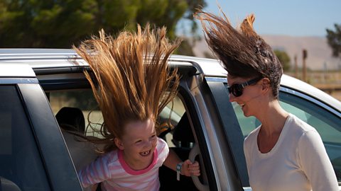 A mother and daughter experience high winds next to their vehicle in central California.