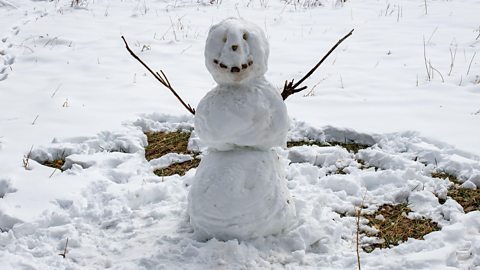 A snowman on a snowy ground.