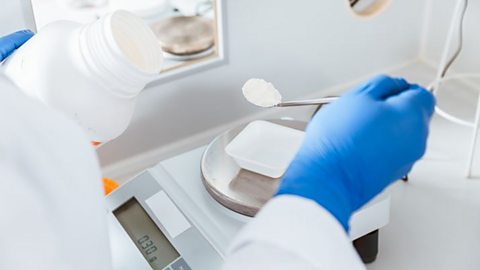 A pharmacist measuring a powder on a scale