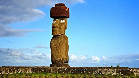 Patricia Hamilton/Getty Images One of the moai has been restored, with its coral eyes and stone hat reminiscent of the original statues (Credit: Patricia Hamilton/Getty Images)