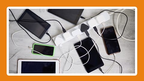 A framed photograph of various tablets and phones all plugged into a plug board