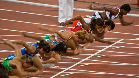 A group of athletes starting a sprint on a race track.