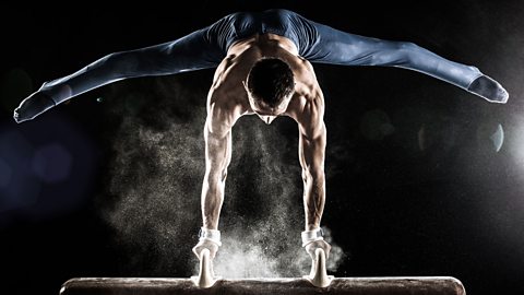 Gymnast with chalked hands on pommel horse