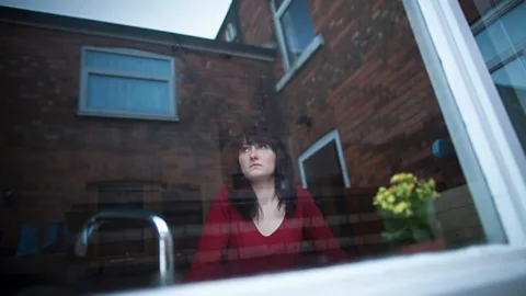 Getty Anxious woman looking out of window