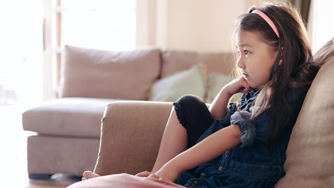 A girl sitting on the sofa looking at something