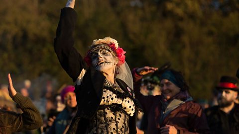 A woman with her face painted as a skull takes part in a Samhain sunset ceremony in Glastonbury