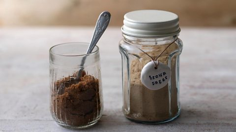 A jar and cup of brown sugar