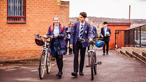 Kids walking into school with bikes