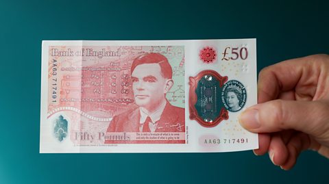 A photograph of a hand holding the Alan Turing £50 note.