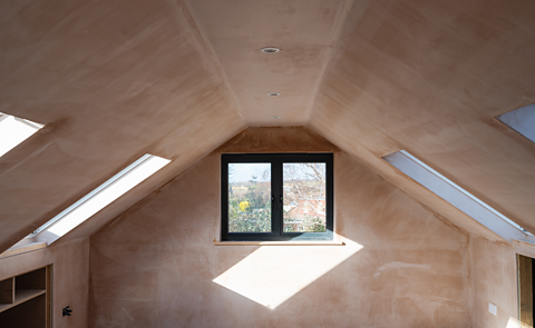 An image of newly plastered walls in an attic with sloping ceilings.