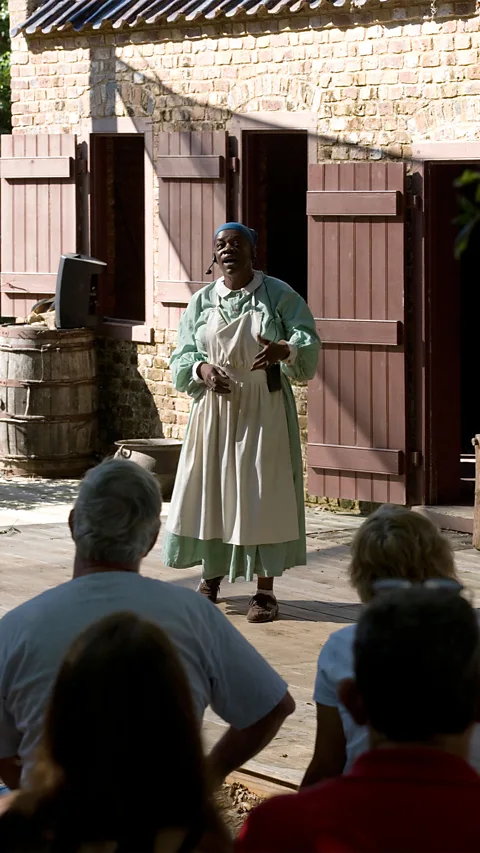 Planetpix/Alamy Historical interpreters tell stories outside the nine cabins that were once the slave quarters at Boone Hall Plantation & Gardens (Credit: Planetpix/Alamy)