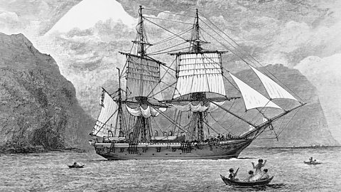 A black and white illustration of the HMS Beagle ship in the Straits of Magellan with Monte Sarmiento in the distance and some smaller boats surrounding it. 